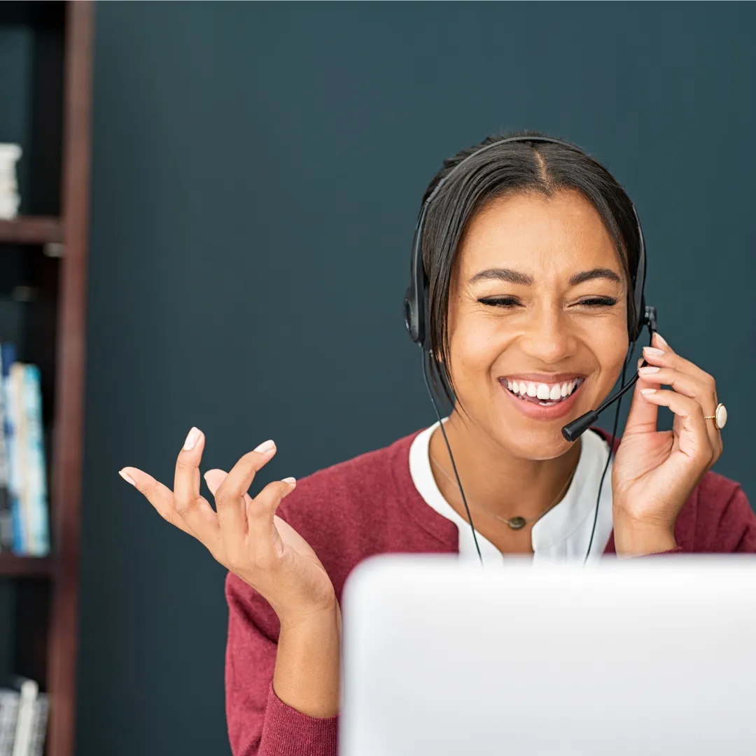 Woman with headset on the phone in front of a computer